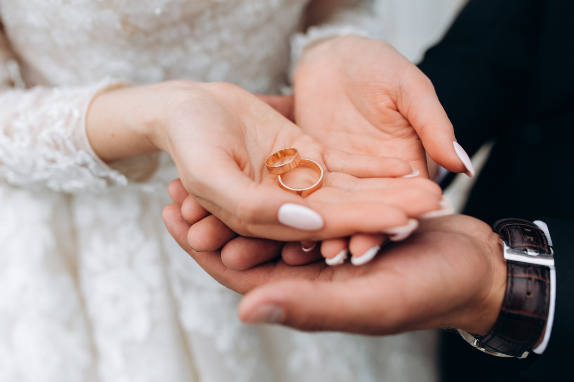 Novios sostienen los anillos de boda